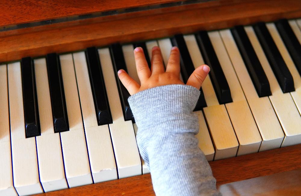 ett barns hand och en piano