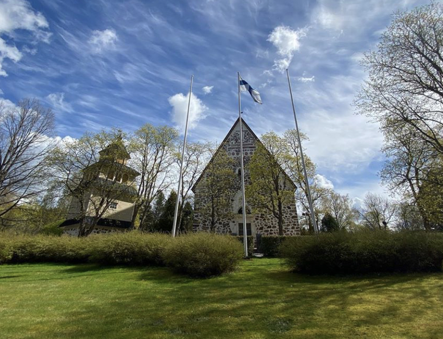 St. Peter's Church in spring with the flag of Finland flying in front of it.